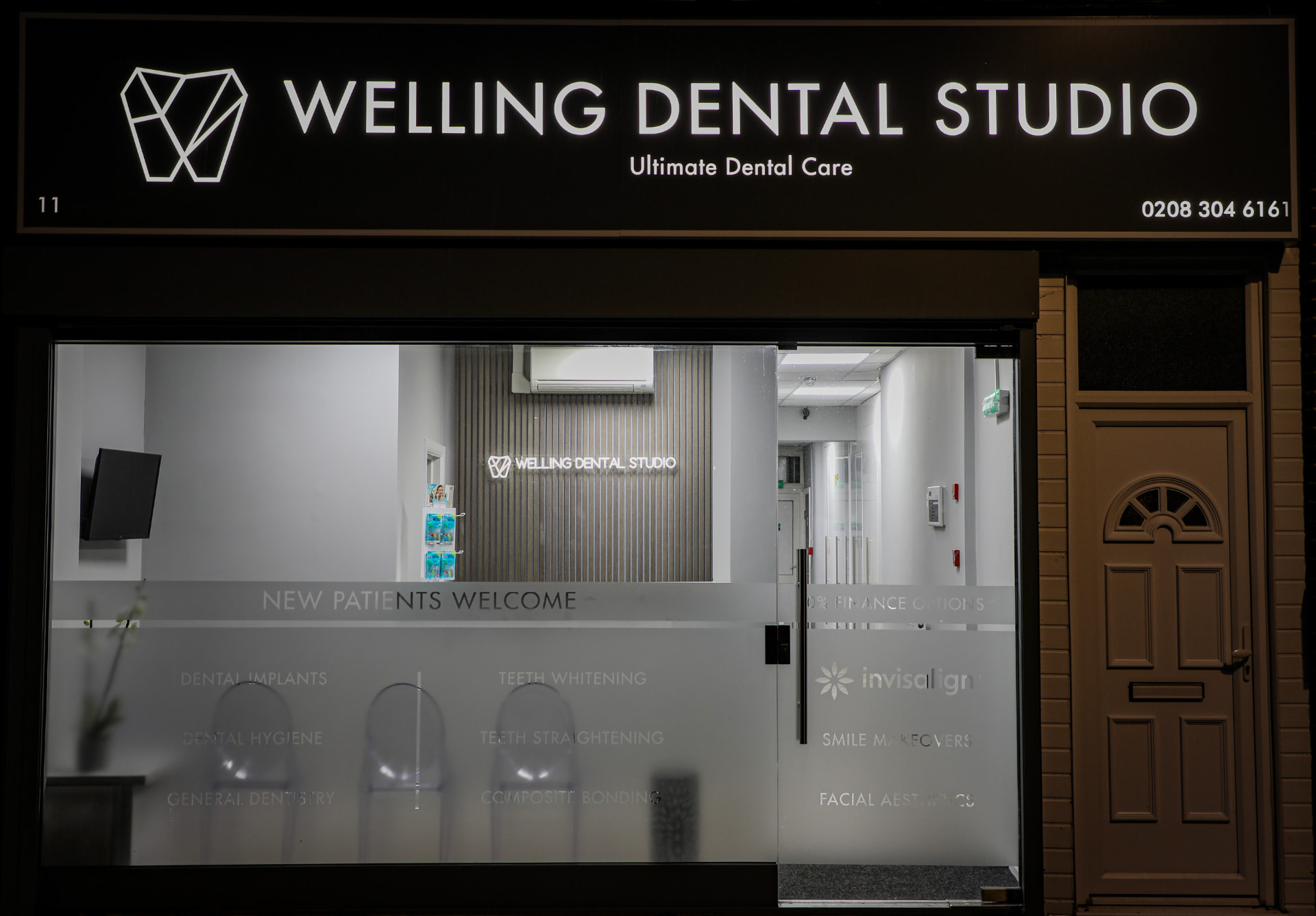The Welling Dental Studio shopfront at 11 Falconwood Parade, lit up at night